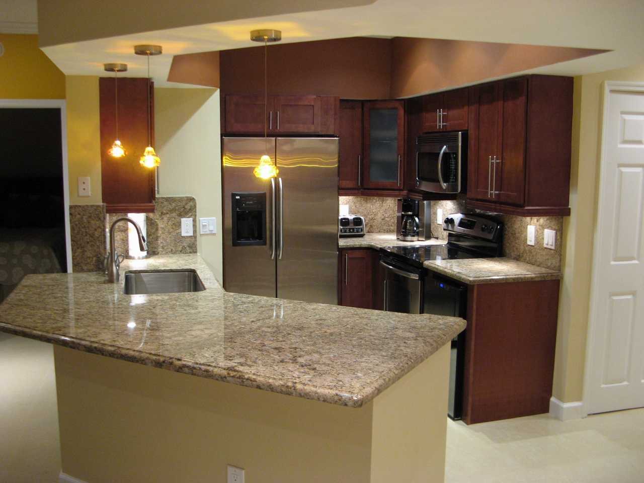 Kitchen remodeling Miami – dark wood cabinets and granite island by Active Builders